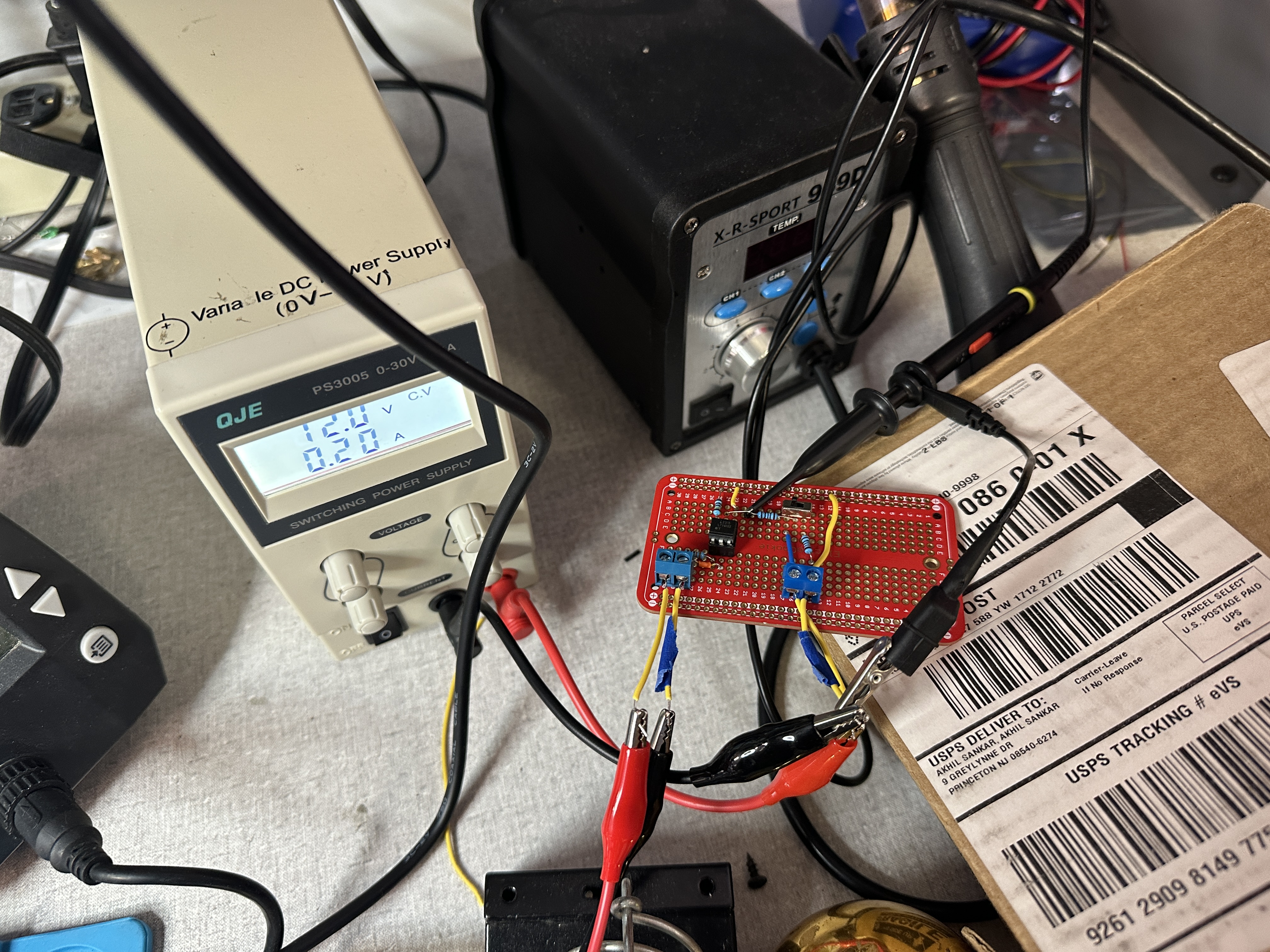 Variable bench supply at 12.0 V / 0.20 A driving the gate-drive side of the solderboard